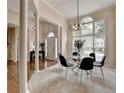 Elegant dining area with a modern chandelier, large windows, and classic columns at 1635 Lake Heights Cir, Dacula, GA 30019