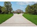 Long driveway leading to a stunning brick home surrounded by a lush green lawn at 5661 Rutland Trce, Lithonia, GA 30058