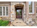 Elegant double front doors framed by stone archway and brick accents at 145 Ardsley Ln, Alpharetta, GA 30005