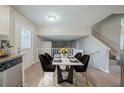 Dining room featuring modern table set atop white rug next to stairwell and open floorplan at 2183 Ramblewood Cir, Decatur, GA 30035