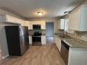 Updated kitchen with stainless steel appliances, granite countertops, and wood-look flooring at 2183 Ramblewood Cir, Decatur, GA 30035
