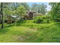 View of the grassy backyard with mature trees and a screened in porch at 3120 Beechwood Se Dr, Marietta, GA 30067