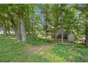 View of house, nestled among mature trees, with visible shed at 3120 Beechwood Se Dr, Marietta, GA 30067
