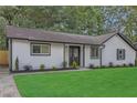 Charming single-story home with a lush green lawn, white siding, black trim, and neatly manicured landscaping at 373 Hemlock Dr, Lawrenceville, GA 30046
