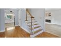 Staircase with hardwood floors, freshly painted white walls, and an adjacent living space at 2316 Fripp Overlook Nw, Acworth, GA 30101