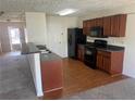 Efficient kitchen featuring black appliances, wooden cabinets, and a breakfast bar with a sink at 730 Georgetown Ln, Jonesboro, GA 30236