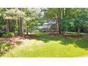 Lush lawn surrounds the exterior of a home with a charming brick facade nestled among the trees at 2179 Mountclaire Ct, Stone Mountain, GA 30087