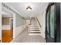 Traditional home foyer with tiled flooring, stairs to the upper level, and decorative wall accents at 2179 Mountclaire Ct, Stone Mountain, GA 30087
