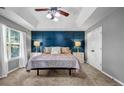 Spacious main bedroom with a tray ceiling, statement wall, plush carpet, and ample natural light at 5485 Shirewick Ln, Lithonia, GA 30058