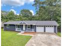 Charming single-story home with a welcoming front porch and a two-car garage, nestled in a lush, green landscape at 4720 Hull Rd, Conyers, GA 30094