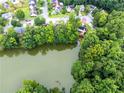 Aerial view of the home near a serene lake, surrounded by lush greenery at 3229 Dunlin Lake Rd, Lawrenceville, GA 30044