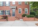 Stylish townhome entrance with red brick, wrought iron railing, and a charming covered entryway at 4130 Stonecypher Rd, Suwanee, GA 30024