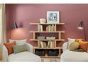 Comfortable living room area, styled with cozy chairs, pillows, and modern shelving at 229 Paisley Way, Locust Grove, GA 30248