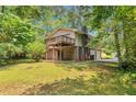 View of the home's rear elevation, showing a private deck and access to a spacious, wooded backyard at 3357 Huntwood Ct, Decatur, GA 30034
