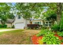A charming home featuring a well-maintained lawn, an attached garage, and mature landscaping at 5279 Leecroft Dr, Buford, GA 30518