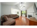 Bright living room with vaulted ceiling, hardwood floors, fireplace, and view to the kitchen at 5279 Leecroft Dr, Buford, GA 30518