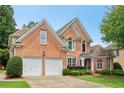 Well-maintained brick home with a two-car garage, neat landscaping, and a spacious driveway at 335 Scarborough Way, Alpharetta, GA 30022