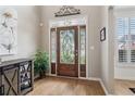 Elegant foyer featuring a decorative wood door with glass panels, hardwood floors, and neutral paint at 335 Scarborough Way, Alpharetta, GA 30022