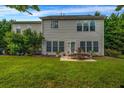 Rear exterior featuring a patio area with outdoor seating and a lush lawn at 15 Saddlebrook Ct, Covington, GA 30016