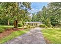 Well-maintained ranch-style home with a long driveway surrounded by mature trees and landscaping at 3440 Wilson Rd, South Fulton, GA 30349
