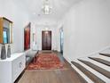 Bright foyer features hardwood floors, a decorative rug, and staircase to the right at 102 Grand Cres, Alpharetta, GA 30009