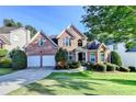 Charming two-story brick home with manicured landscaping, a two-car garage, and a beautiful lawn at 1301 Dayspring Trce, Lawrenceville, GA 30045