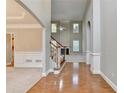 Spacious foyer with hardwood floors, a staircase, and views into a living room with fireplace at 1301 Dayspring Trce, Lawrenceville, GA 30045