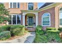 Inviting front entrance with a dark-colored door, manicured shrubbery, and stone walkway at 1301 Dayspring Trce, Lawrenceville, GA 30045