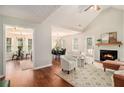 Bright living room featuring a cozy fireplace, vaulted ceiling, and hardwood floors at 215 Nina Circle Cir, Locust Grove, GA 30248