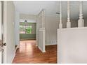 Inviting entryway with wood floors, neutral walls, and decorative spindles leading to other living spaces at 140 Carriage Cir, Stockbridge, GA 30281