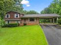 Charming home with a brick facade, wood siding, covered parking, and a well-manicured front yard at 140 Carriage Cir, Stockbridge, GA 30281