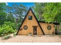 Charming A-frame home showcasing wood siding, black trim, and unique round windows at 3620 Beaver Cove Rd, Cumming, GA 30041