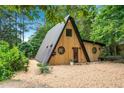 A-frame home showcasing wood siding, a metal roof, round windows, and ample parking space at 3620 Beaver Cove Rd, Cumming, GA 30041