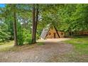 Exterior view of A-frame home with natural wood siding in a wooded, serene environment at 3620 Beaver Cove Rd, Cumming, GA 30041