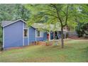 Backyard view of home with mature trees and swing hanging from tree at 3076 Montheath Pass, Duluth, GA 30096