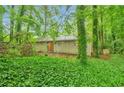 Rear exterior view of a home surrounded by lush trees and greenery at 5577 Whittondale Rd, Lithonia, GA 30058