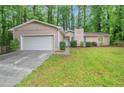 Exterior front view of a single-story home with attached garage and green lawn at 5577 Whittondale Rd, Lithonia, GA 30058