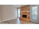 Open living room featuring wood-look flooring and fireplace with tiled hearth at 5577 Whittondale Rd, Lithonia, GA 30058