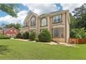 Angle-shot of a house with healthy green lawn and lush green trees with a glimpse of neighboring home at 2851 Weatherstone Se Cir, Conyers, GA 30094