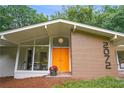 Inviting covered front porch with brick accents and a brightly colored front door at 2072 Castleway Ne Dr, Atlanta, GA 30345