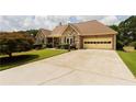 Lovely exterior view highlighting stone facade, attached garage, and a large concrete driveway at 3785 Glen Ian Dr, Loganville, GA 30052