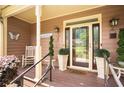 Inviting front porch with rocking chair, plants, and decorative accents leading to the front door at 3785 Glen Ian Dr, Loganville, GA 30052