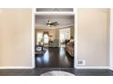 Open doorway to a living room with dark floors, fan, and views into other rooms at 3785 Glen Ian Dr, Loganville, GA 30052