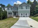 Charming two-story home with green siding, a two-car garage and well manicured landscaping at 66 Pine Creek Ct, Dallas, GA 30157
