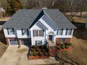 Captivating aerial view of a two-story house featuring a well-maintained lawn, mature trees, and an attached two-car garage at 1305 Bramlett Forest Trail Southeast Trl, Lawrenceville, GA 30045