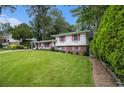 Charming split-level home with a well-manicured lawn and colorful shutters at 2983 Peek Nw Rd, Atlanta, GA 30318