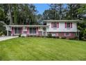 Charming split-level home with a well-manicured lawn and colorful shutters at 2983 Peek Nw Rd, Atlanta, GA 30318