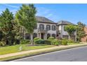 Beautiful home featuring a manicured lawn and a symmetrical facade with a charming balcony and attached two-car garage at 3015 Southmoor Trce, Roswell, GA 30075