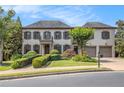 Beautiful home featuring a manicured lawn and a symmetrical facade with a charming balcony and attached two-car garage at 3015 Southmoor Trce, Roswell, GA 30075