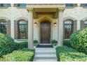 Inviting front entrance with stone columns, arched windows, lush landscaping, and a stained wood door with sidelights at 3015 Southmoor Trce, Roswell, GA 30075